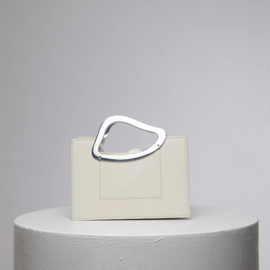 The mini bag version of Arp’s Sailent is combines vintage elegance, modernity and sophistication with a minimal clean cut. It's organic shaped metal handles are indicative of Naturae Sacra’s signature design detailing. This un-conventional handles design has been crafted to allow ergonomic gripping. Design process of Arp’s Sailent took an inspration by Hans (jean) Arp’s ‘silence’ named abstract sculpture which is most simple but most compelling. 

DETAILS

13cm (H) x 19cm (W) x 10cm (D),
Calf Leather Magnetic closures Metal handle
Long cross-body strap Two accordion-like compartments
Embossed NATURAE SACRA lettering at the front
Two interior pouch pocket
A card holding slit at the back Dust bag and branded box included 


 
 




PRODUCT CARE
CALF LEATHER:   Each leather hides unique characteristics such as texture and natural markings. Also, the most prominent feature of vegetal tanned leather is that it changes color with usage. Aging and tone variations should not be considered an imperfection as leather is a natural product. Please, avoid contact with water and any oil-based substances. 
METAL HANDLES:  Metal handles are handmade and each piece has its unique points, which means that there are no two alike pieces. 
  
Fulfilled by our friends at NATURAE SACRA 
*Please Note: 

 Rewards cannot be applied to this product
This item is not eligible for returns 
This item cannot be shipped outside the U.S.

  

 
